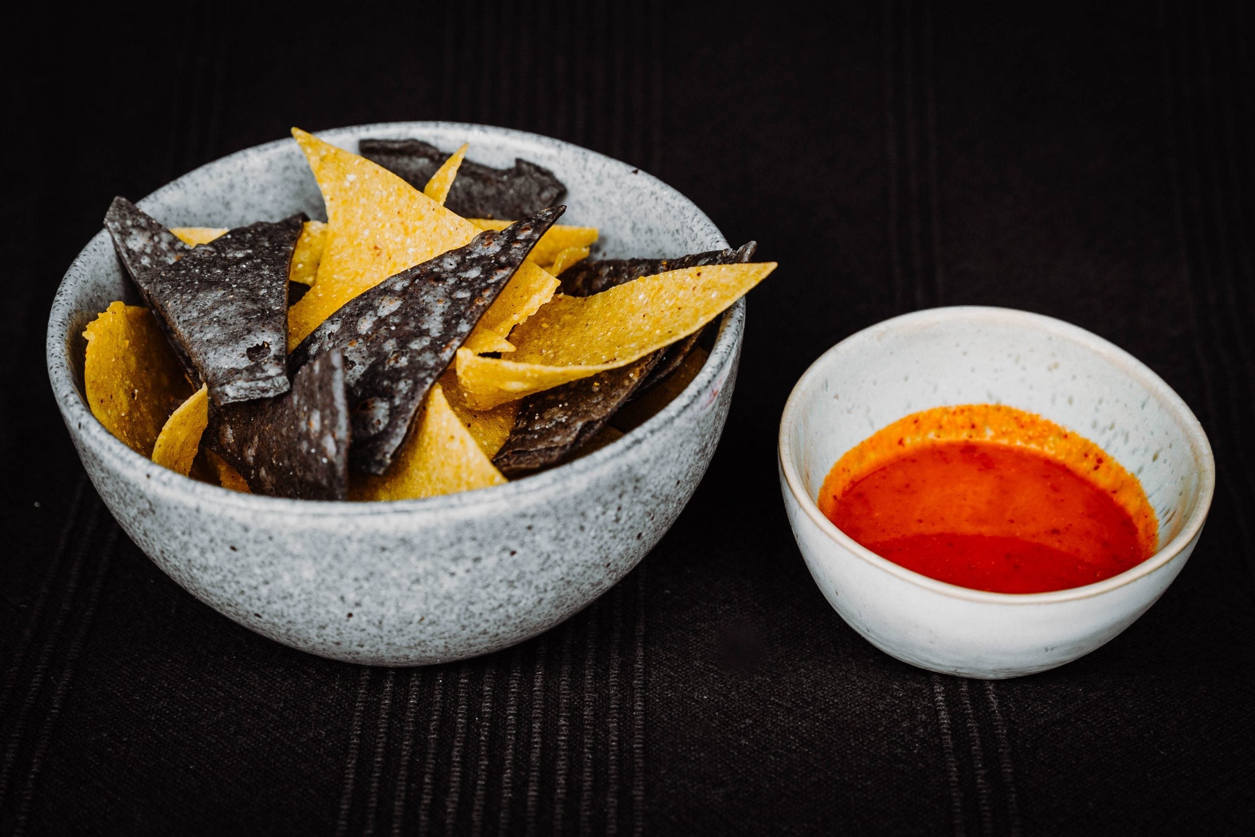 Hausgemachte Tortilla Chips von Wrapstars mit einer hausgemachten Salsa daneben in kleinen Schüsseln