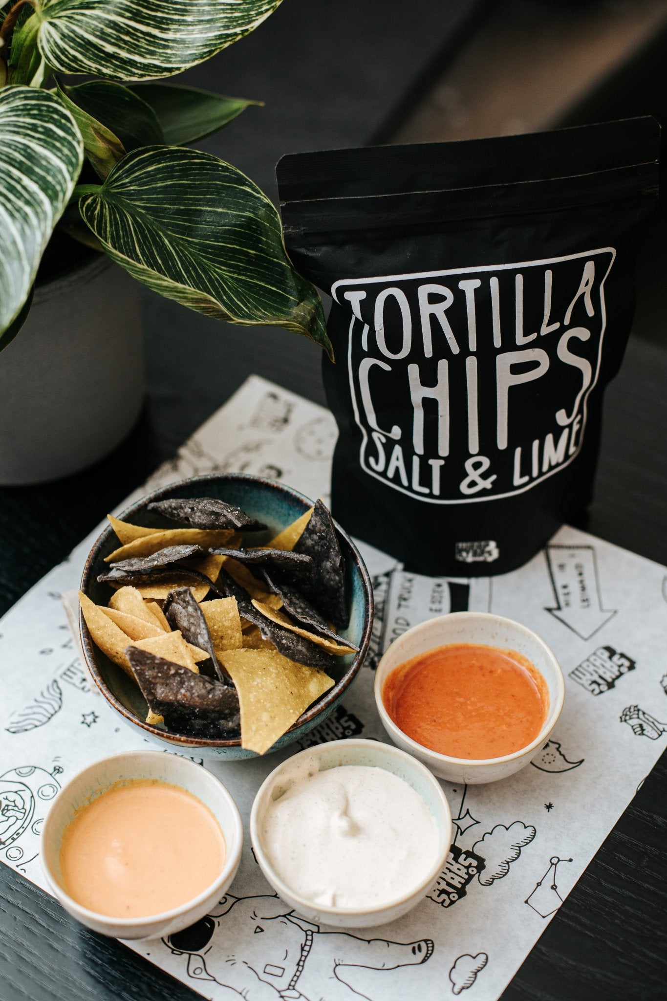 A bag of home-made tortilla chips with dips from the house