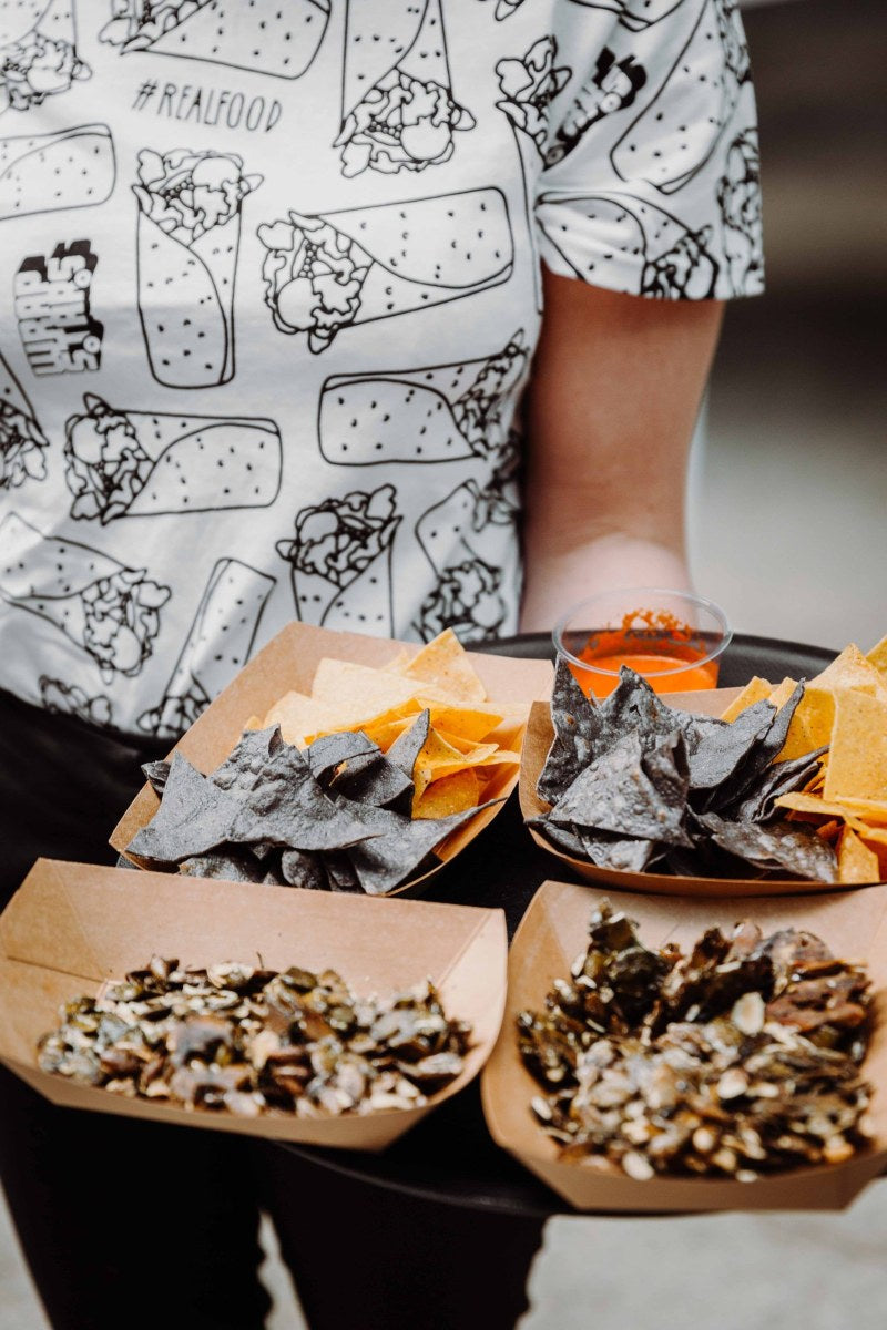 Schalen gefüllt mit Tortilla-Chips und einer Auswahl an karamelisierten Kürbiskernen.